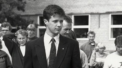 Kronprins Frederik i 1989, går gennem universitetsparken omgivet af andre studerende.