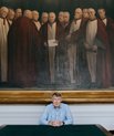 Højesteretspræsident Jens Peter Christensen foran et maleri af gamle højesteretsdommere. 