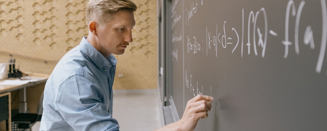 Lektor Mikkel Bennedsen står ved tavlen. 