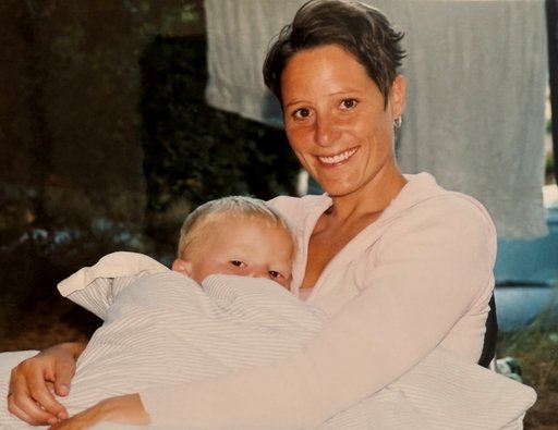 Cecilia Ramlau Hansen med et lille barn i en dyne. Billedet er fra cirka 2001.
