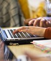 Hænder taster på tastaturet på en bærbar pc